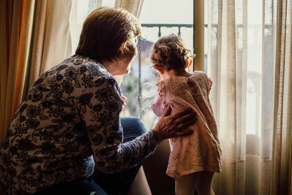 grandmother and child looking out window